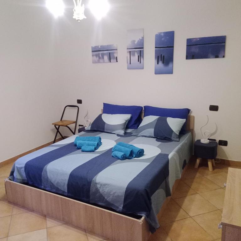 a bedroom with a large bed with blue towels on it at Appartamento BLU - Colori del Lago D'Orta - NUOVA STRUTTURA A OMEGNA in Omegna