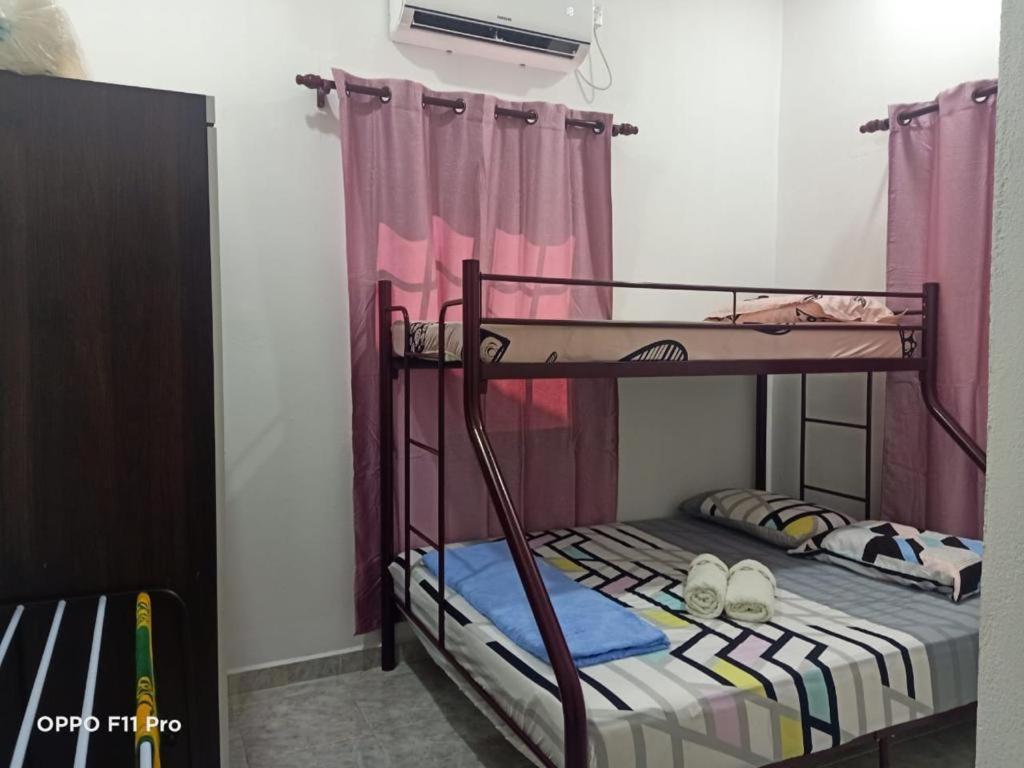 a bedroom with two bunk beds in a room at Safiyya Homestay in Pantai Cenang