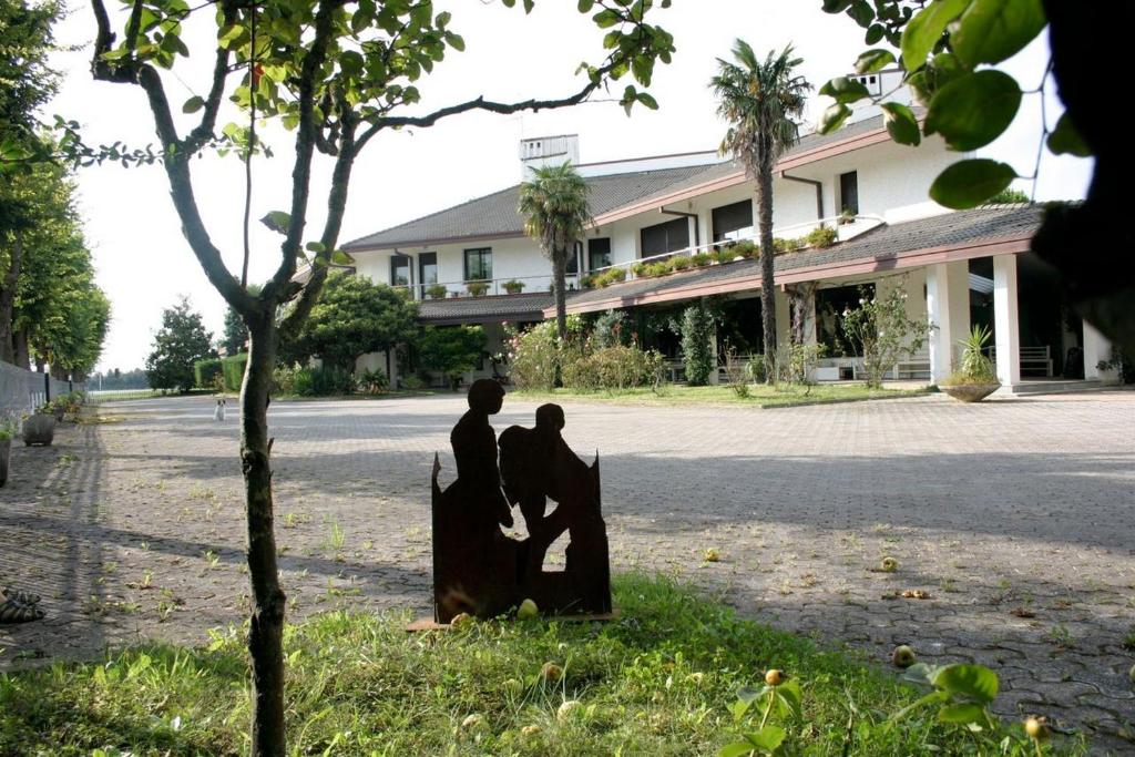 Deux statues de deux personnes debout sur une clôture devant un bâtiment dans l'établissement B&B Cà d'Artisti, à Caorle