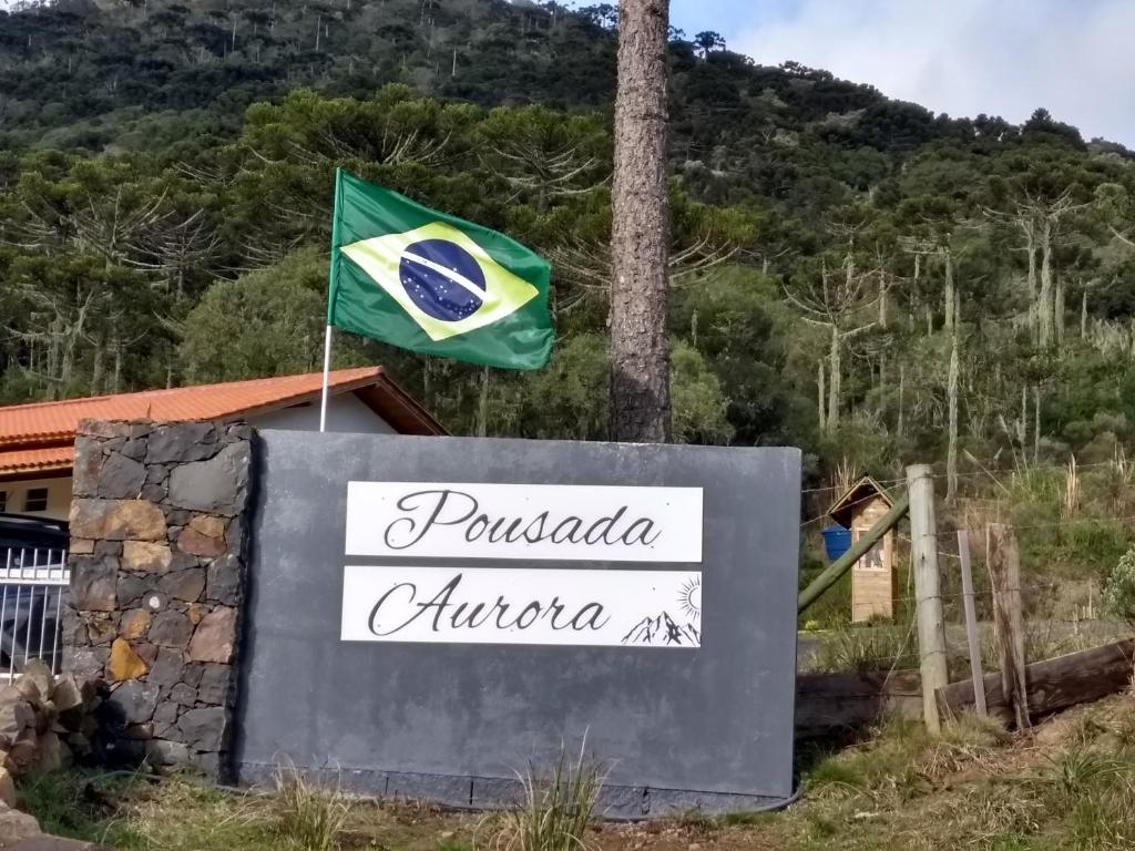 a flag flying over the sign of a resort at POUSADA AURORA in Mundo Novo