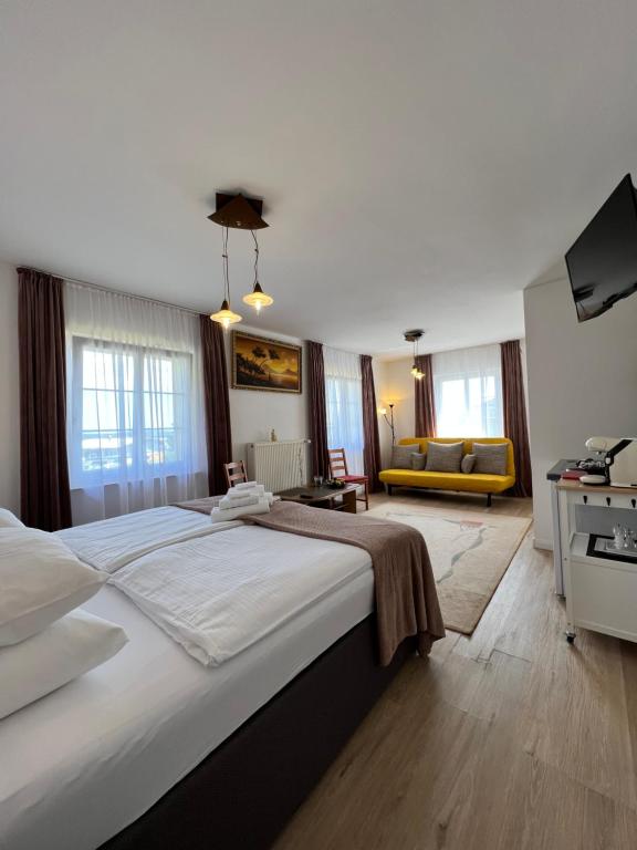 ein Schlafzimmer mit einem großen Bett und ein Wohnzimmer in der Unterkunft Aparts4ring Nürburg - Private Rooms in Nürburg