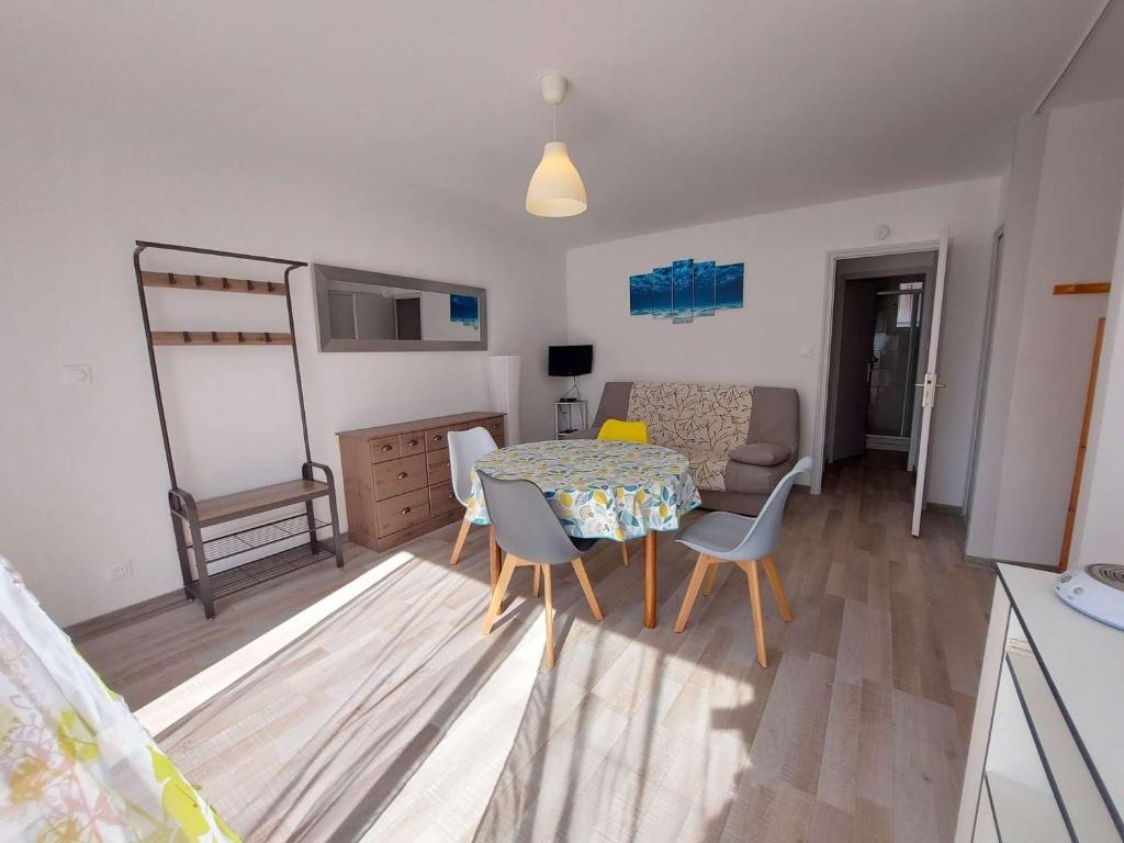 un salon avec une table et des chaises de salle à manger dans l'établissement Appartement lumineux 4-6 pers avec terrasse, parking et cuisine équipée à Marseillan - FR-1-326-502, à Marseillan