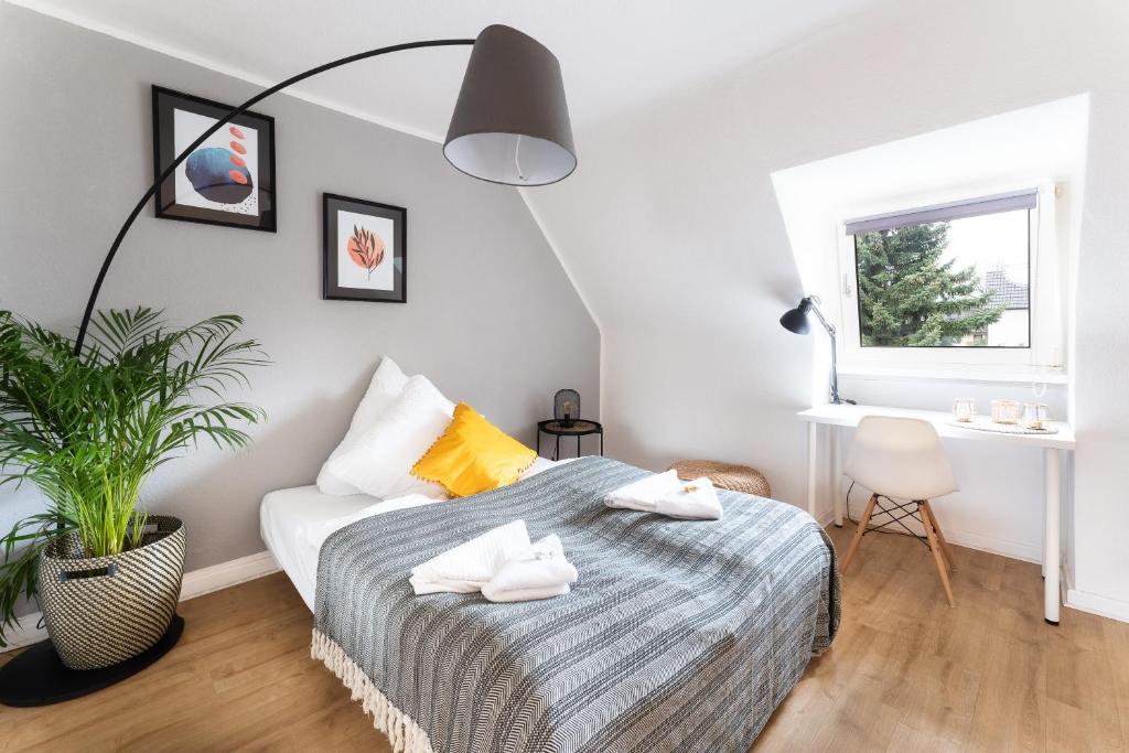 um quarto com uma cama e um vaso de plantas em Stay Awesome - Modernes Apartment am Botanischen Garten em Kassel