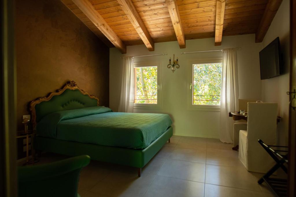a bedroom with a green bed and two windows at Ca' Ottantanove in Mestre