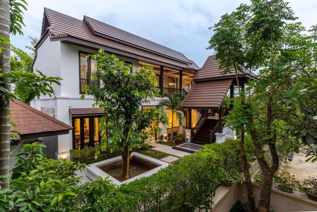 an exterior view of a house with trees at Sclass 2 Luxe Pools Villa & Breakfast , city area in Chiang Mai