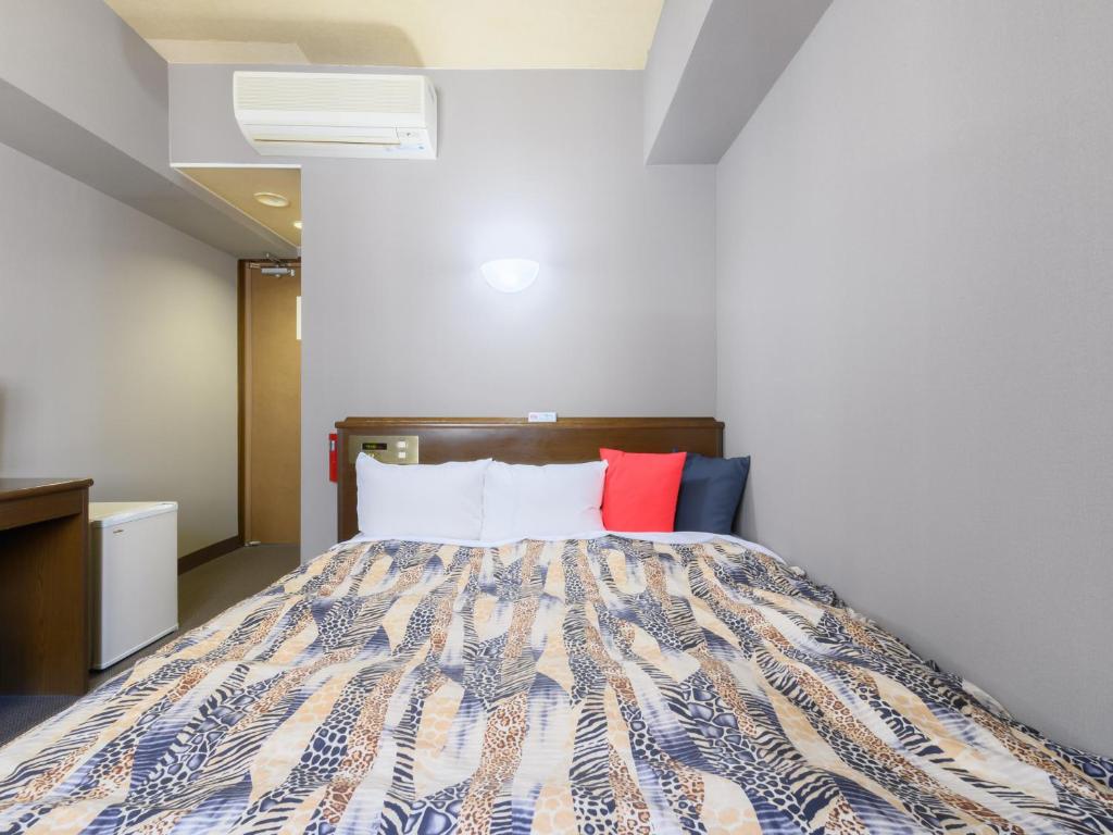 Postel nebo postele na pokoji v ubytování Tabist IWATA Station Hotel