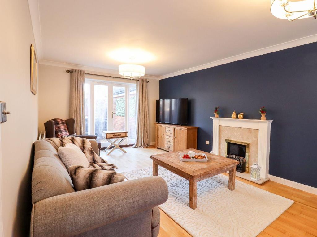 a living room with a couch and a fireplace at Cherry Blossom Place in Tiptree