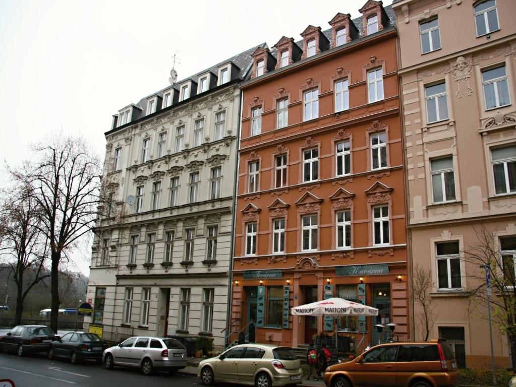 a row of buildings on a street with parked cars at Apartmán Dr. Engla in Karlovy Vary
