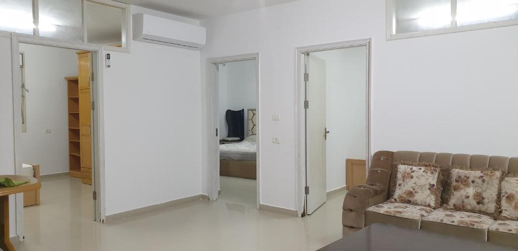- un salon avec un canapé et une chambre dans l'établissement Nice Apartment in Hebron Palestine, à Khirbat an Naşārá