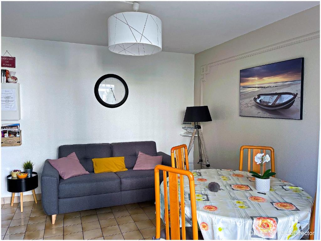 un salon avec un canapé et une table dans l'établissement Cabourg, Appartement plain pied avec terrasse accès direct à la plage, à Cabourg