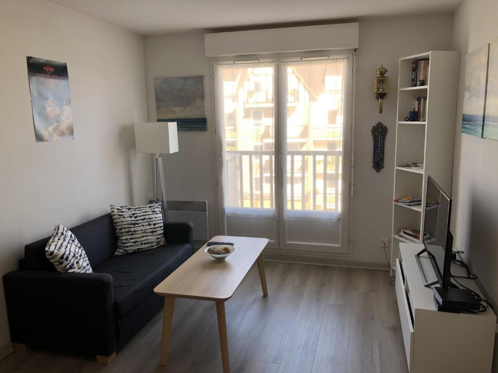un salon avec un canapé et une table dans l'établissement Cabourg: Appartement bord de mer, balcon, internet, parking - FR-1-487-313, à Cabourg