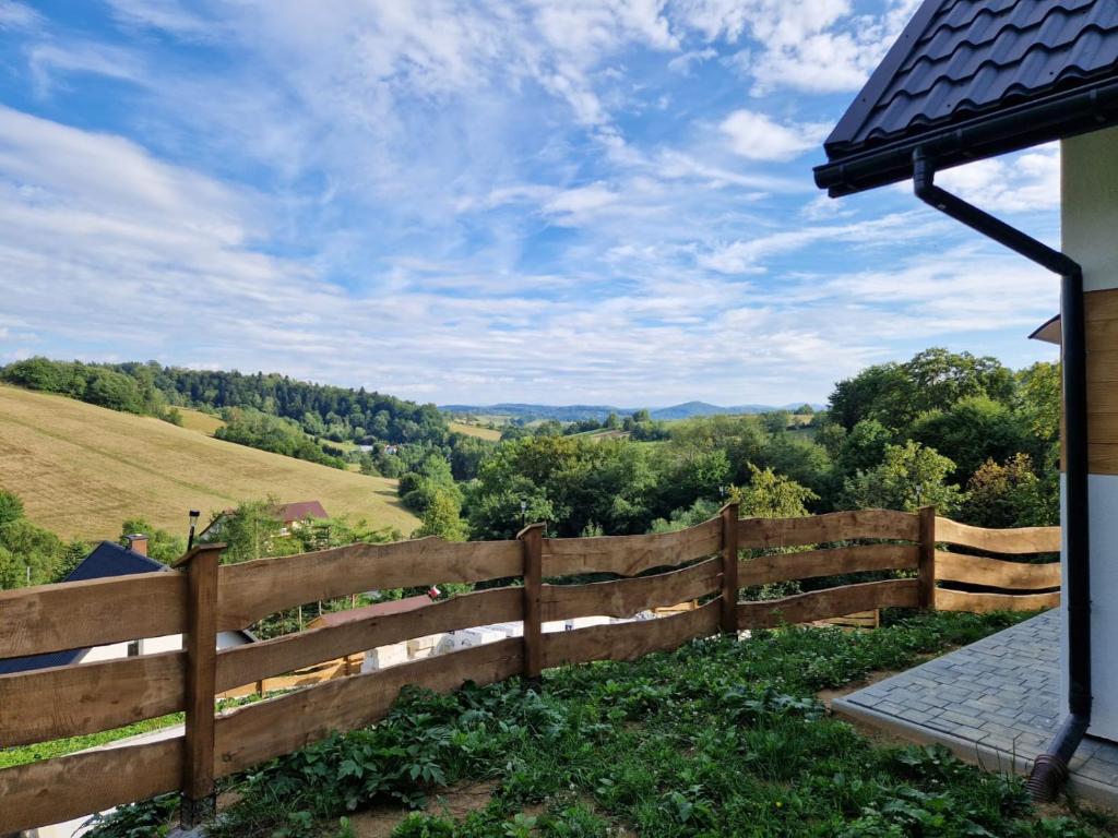 a wooden fence with a view of the countryside at Sielska Osada - domki całoroczne in Rudenka