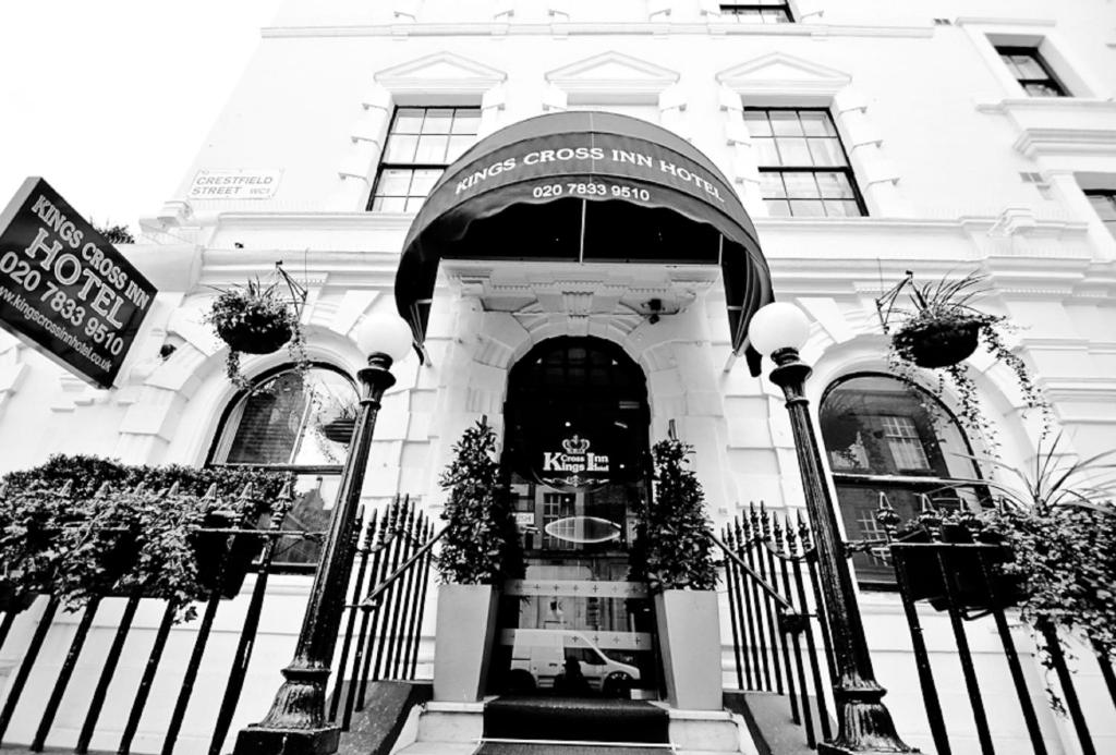 uma foto a preto e branco de um edifício branco em Kings Cross Inn Hotel em Londres