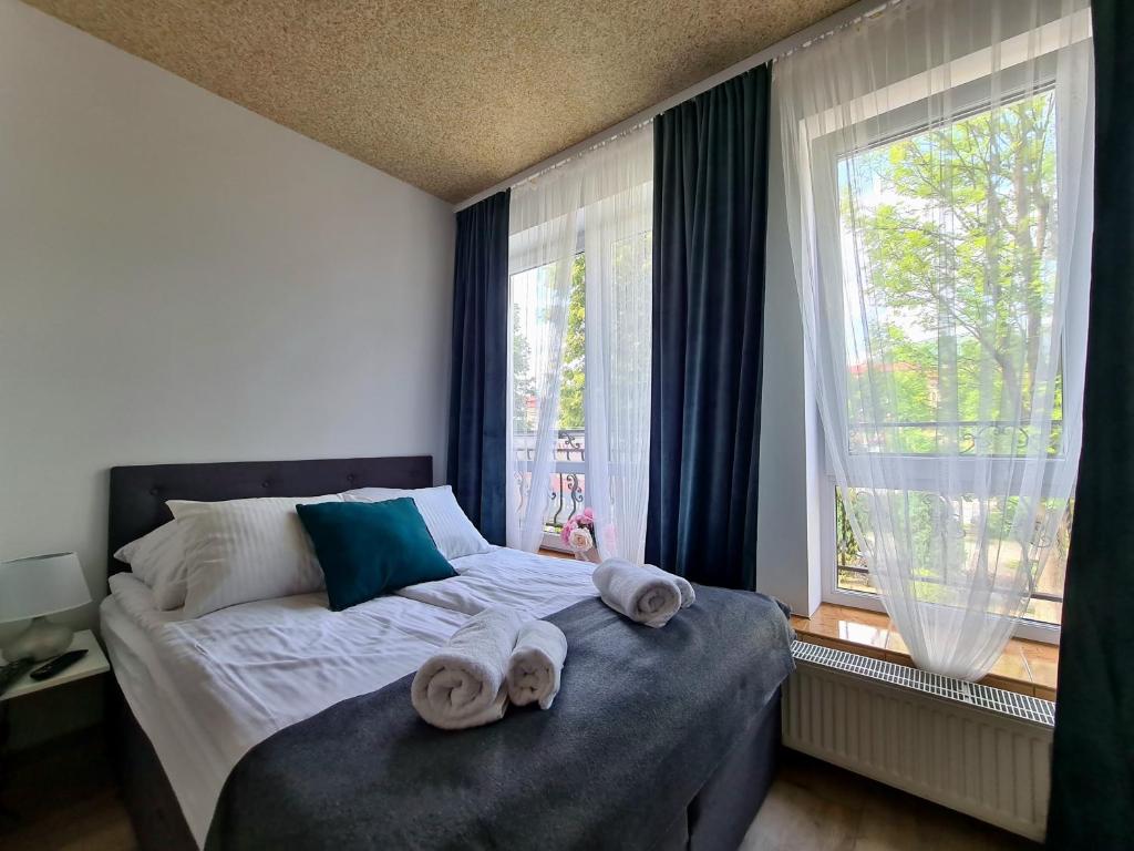 a bedroom with towels on a bed with a window at Apartamenty Katarina in Ustrzyki Dolne