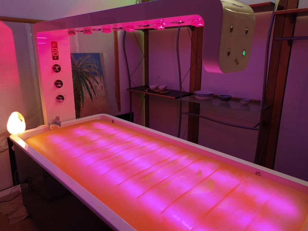 a room with a bed with pink lights on it at B&B Cà d'Artisti in Caorle