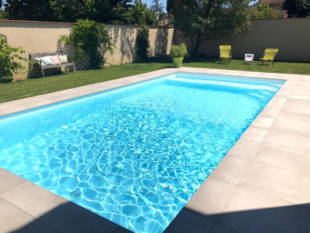 a swimming pool with blue water in a yard at La Case a Mamy in Nianing