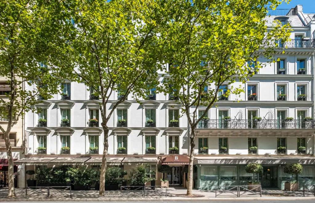 a white building with trees in front of it at Hôtel La Bourdonnais by Inwood Hotels in Paris