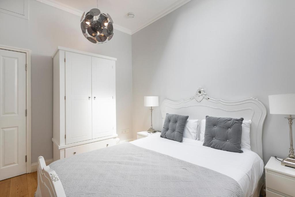 um quarto branco com uma cama branca e 2 almofadas em PenthouseStays Notting Hill - Spacious 3 Bedroom King Bed Apartment - near Portobello Road & Kensington High Street em Londres