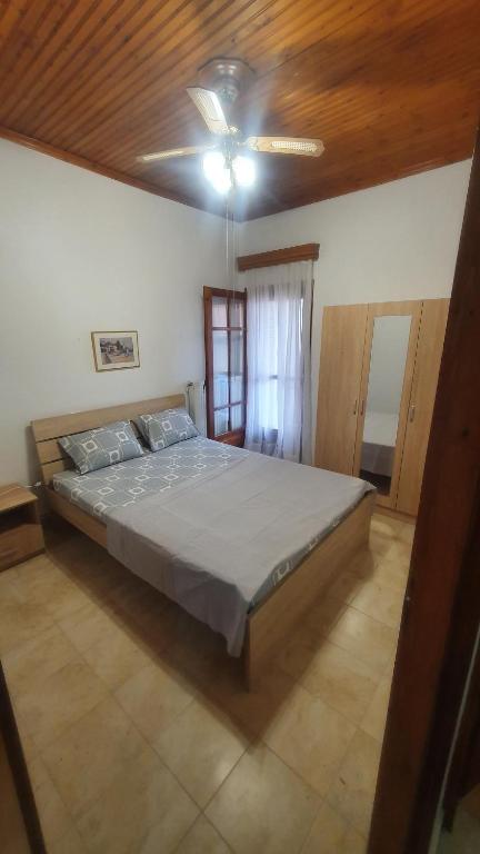 a bedroom with a bed and a ceiling fan at Adorable 2 floors two bedroom vacation maisonette in Nea Potidaea