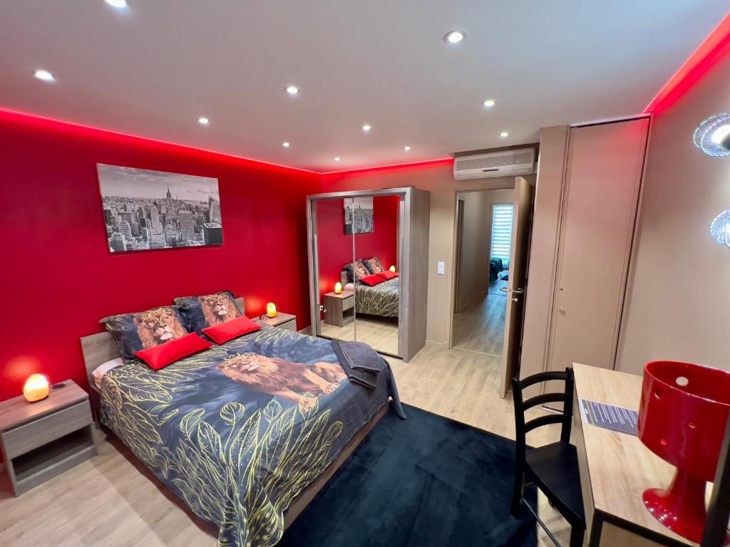 1 dormitorio con paredes rojas, 1 cama y 1 mesa en ATELIER DES REVES - au coeur de Besancon - 88 m2, en Besançon