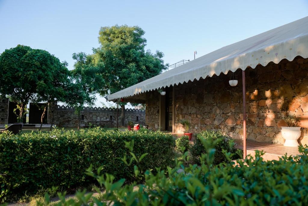 una casa de piedra con una pared de piedra y un patio en The Rustic Villa, a stay with luxuries amenities and exotic nature, en Jaipur