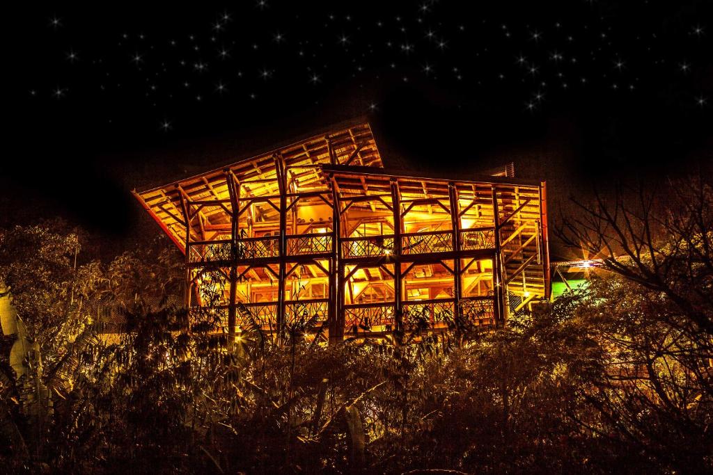 a building lit up at night with lights at Bambu Guest House in Tzununá