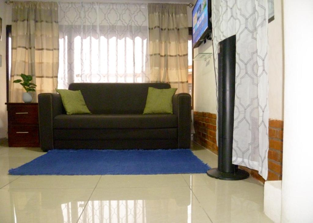 salon z kanapą i telewizorem w obiekcie Nice private apartment studio to discover CR w mieście Alajuela