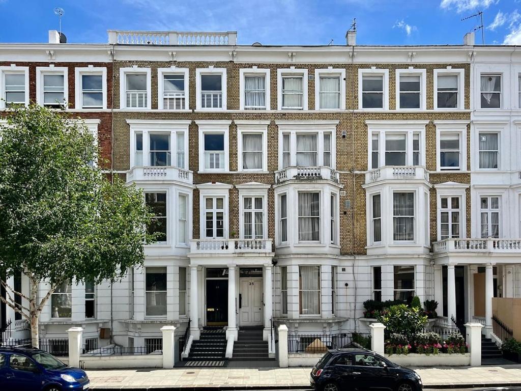 a large brick building with white windows and stairs at Imperial Earls Court Apartments in London