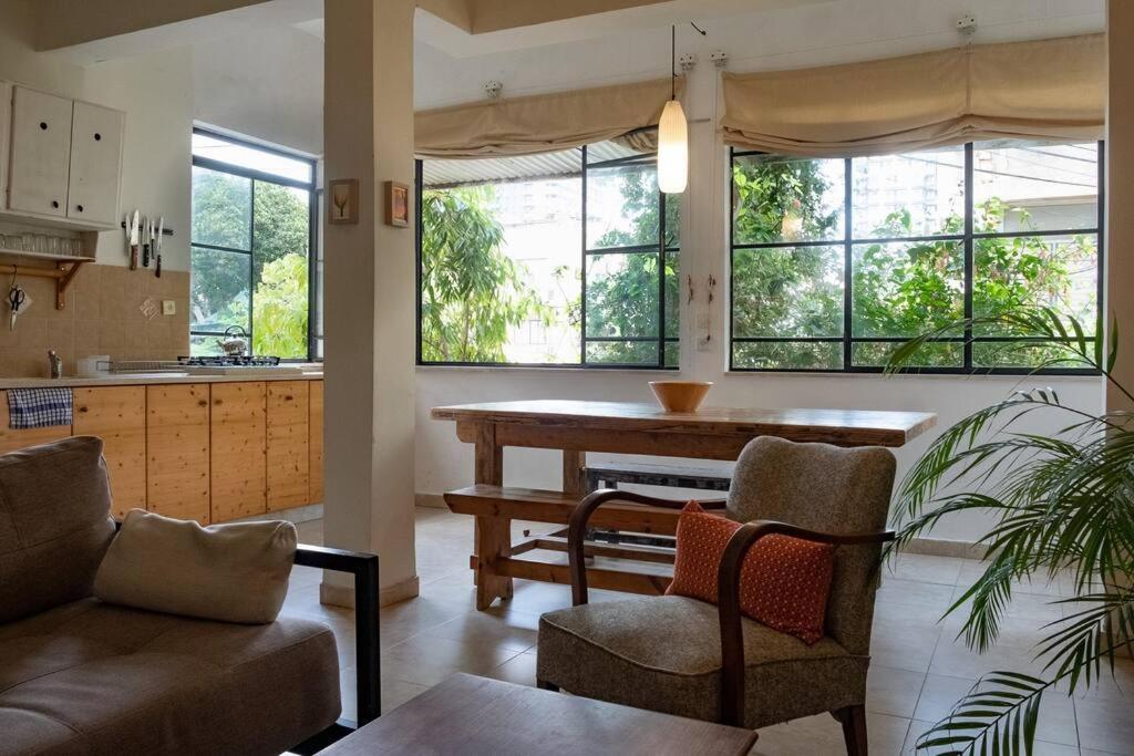 a kitchen and living room with a table and chairs at CHARMING APARTMENT AT UNBEATABLE SPOT in Tel Aviv