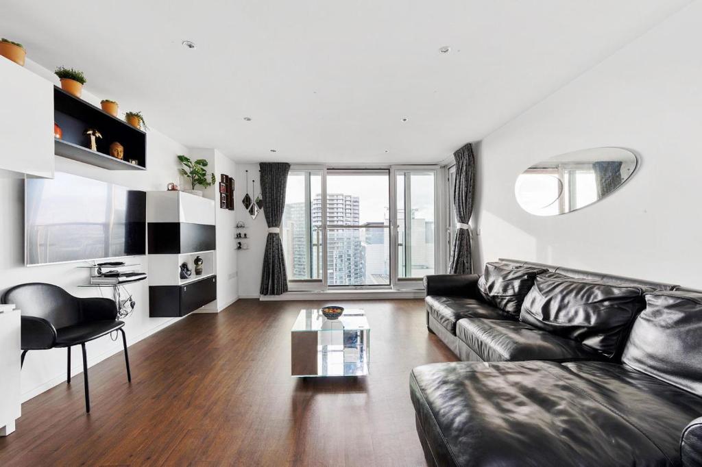 ロンドンにあるTwo Bedroom Apartment - London ExCeL Staysのリビングルーム(革張りのソファ、テーブル付)