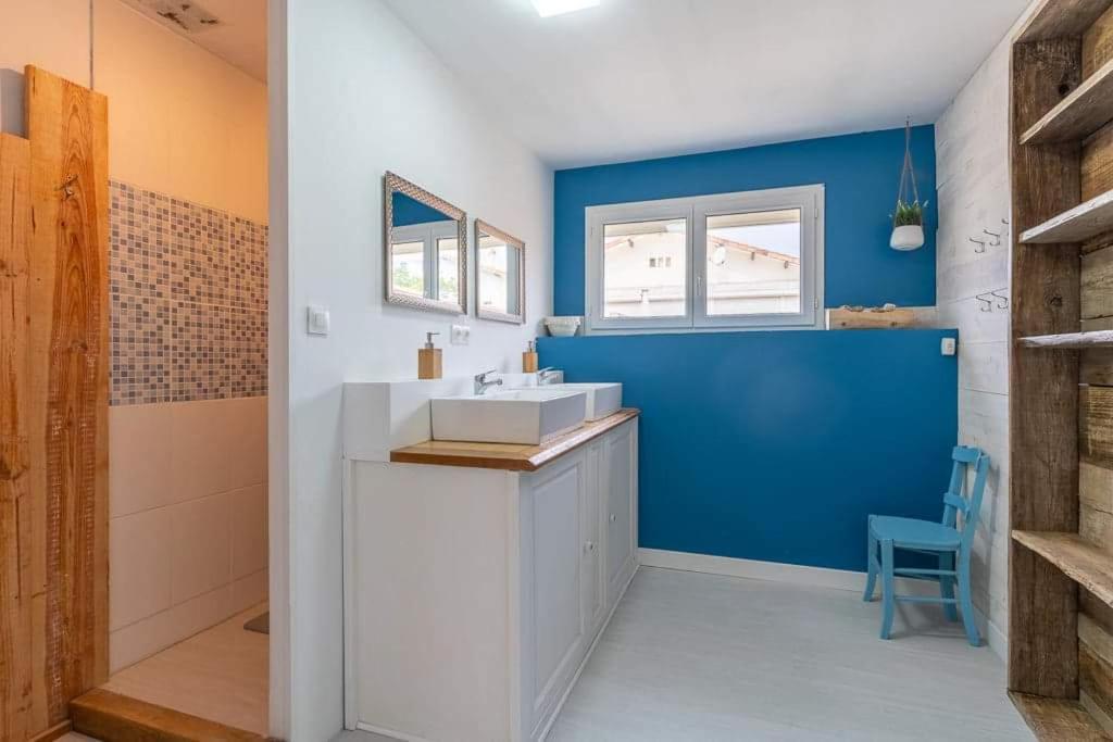 a bathroom with a white sink and a blue wall at Maison Mimizan plage in Mimizan