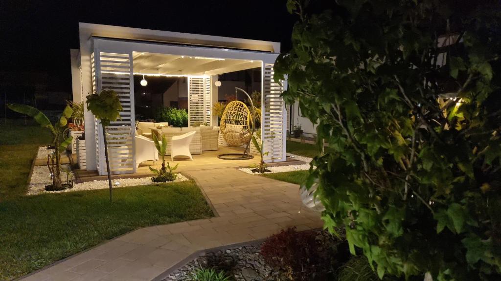 a pergola in a garden at night at Apartamenty Biała Perła in Jastrzębia Góra