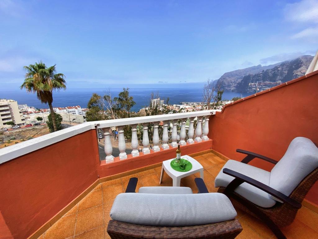 balkon z krzesłami i stołem i oceanem w obiekcie Panorama Ocean View Gigantes w mieście Santiago del Teide