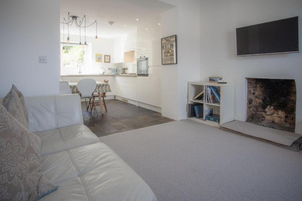 ein Wohnzimmer mit einer weißen Couch und einem Kamin in der Unterkunft Ty Golau - 3 Bed Holiday Home - Pembroke in Pembroke