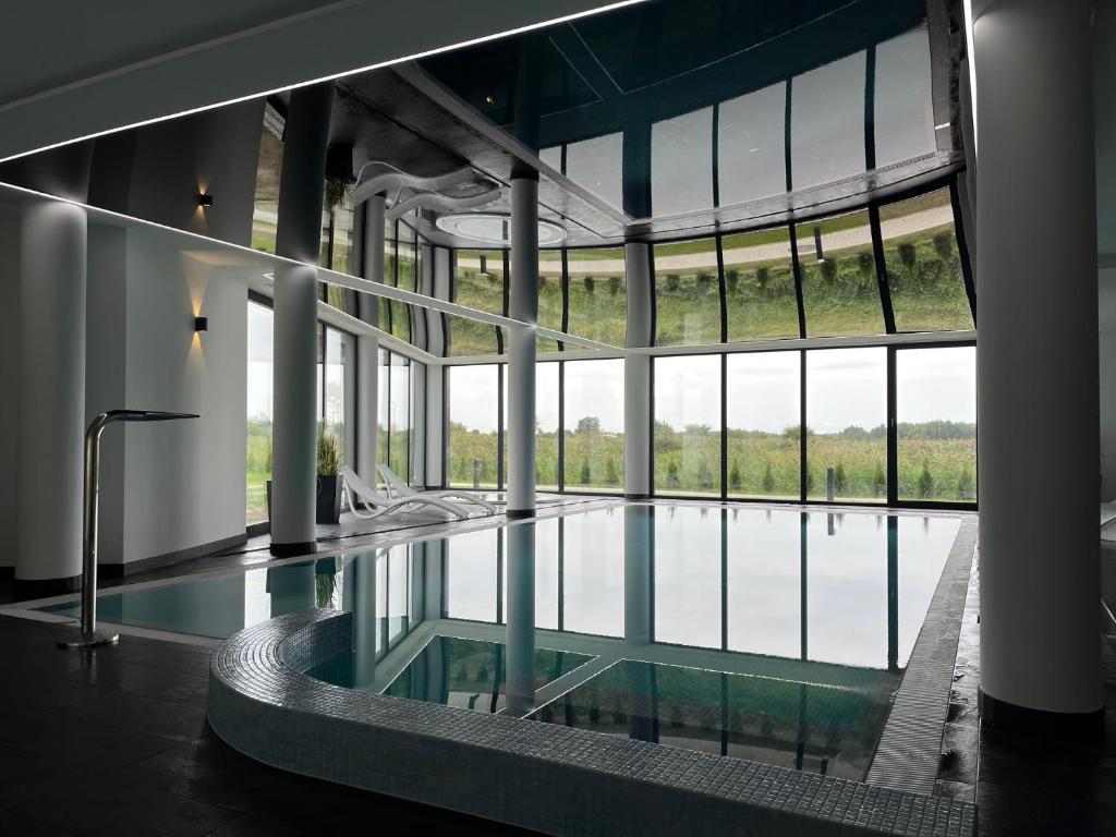 ein großer Pool in einem Gebäude mit einem großen Fenster in der Unterkunft Apartament w Westin House Resort Kołobrzeg in Kołobrzeg