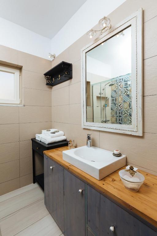 a bathroom with a sink and a mirror at Silene Villas in Amoopi