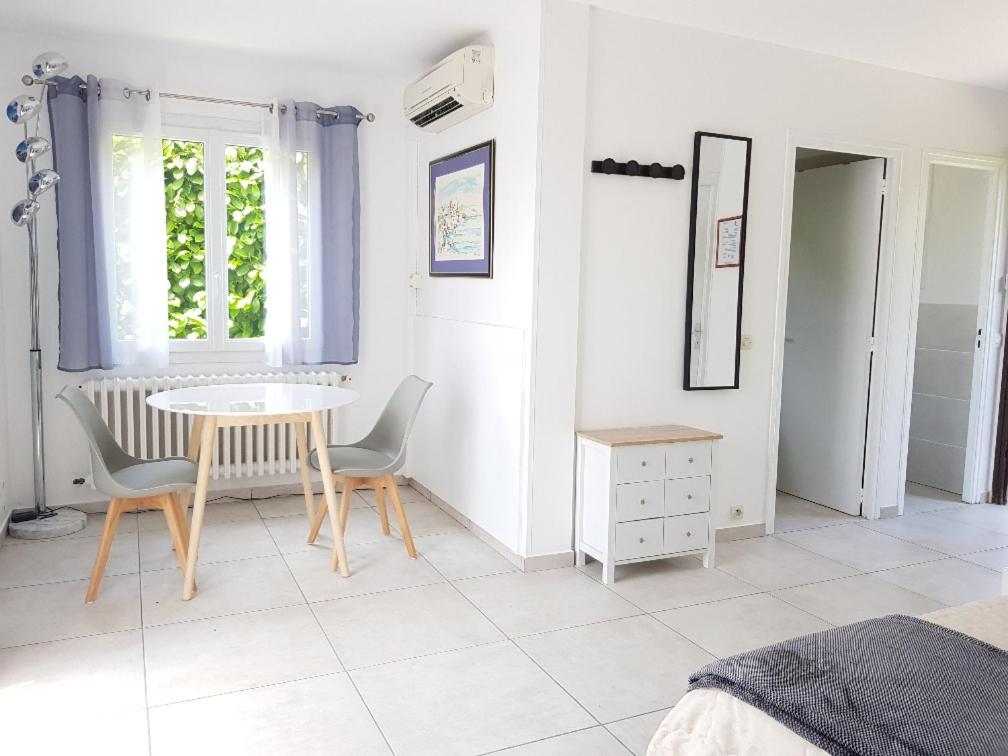 une pièce avec une table, des chaises et une fenêtre dans l'établissement Studio au calme, proche commerces et plages, à Antibes