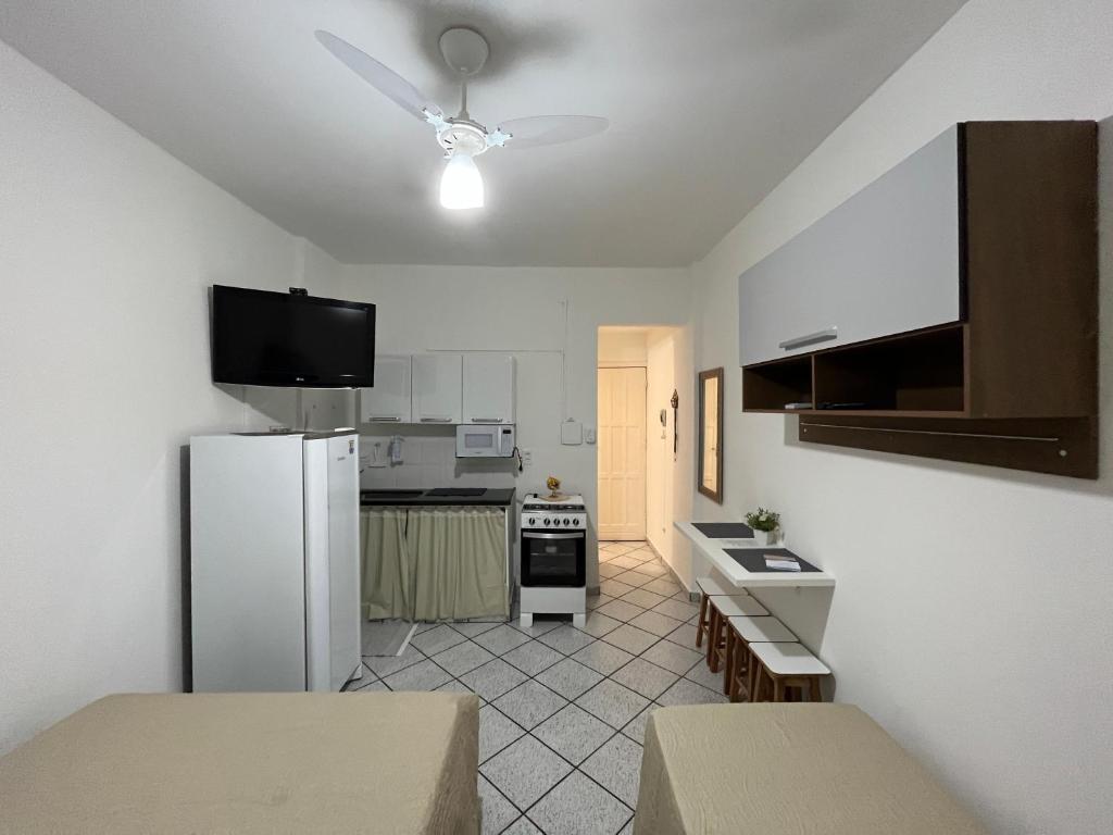 a kitchen with a white refrigerator and a stove at KITNET ACONCHEGANTE A 3 MINUTOS DA PRAIA in Guarapari