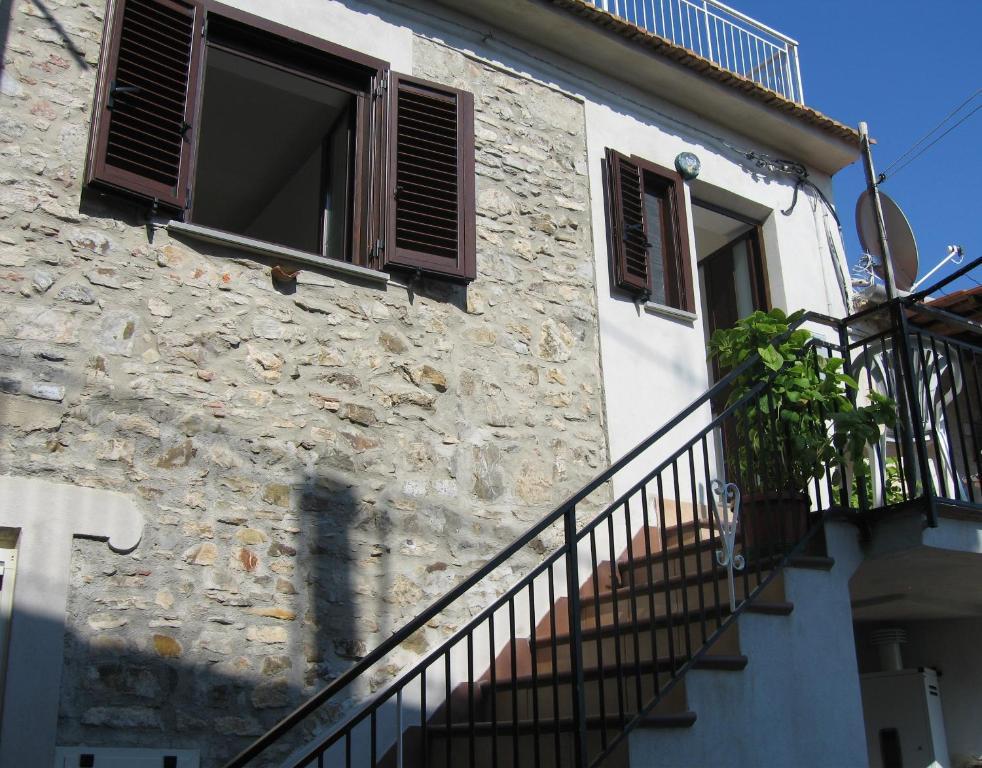 a stone building with a staircase leading to a window at Casa Maria Russo in Casal Velino
