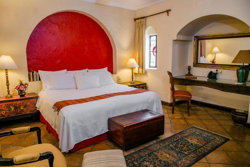 グアダラハラにあるヴィラ ガンツ ブティック ホテルのベッドルーム1室(赤いヘッドボード付きの大型ベッド1台付)