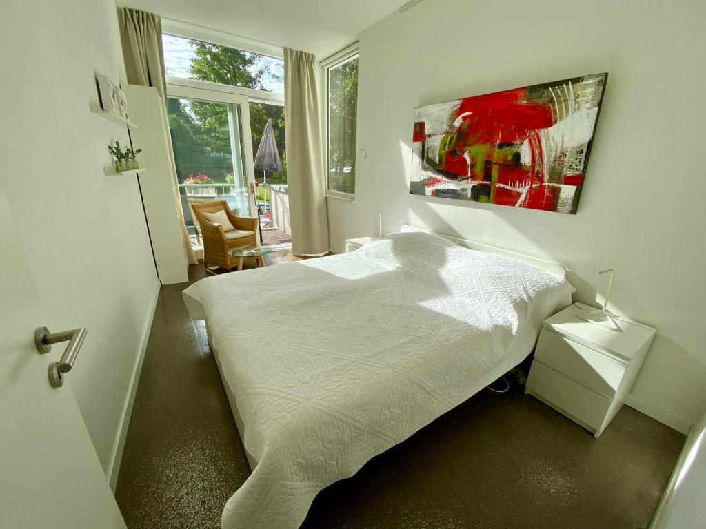 a bedroom with a white bed and a window at Atelier-Ferienwohnung in Mülheim an der Ruhr