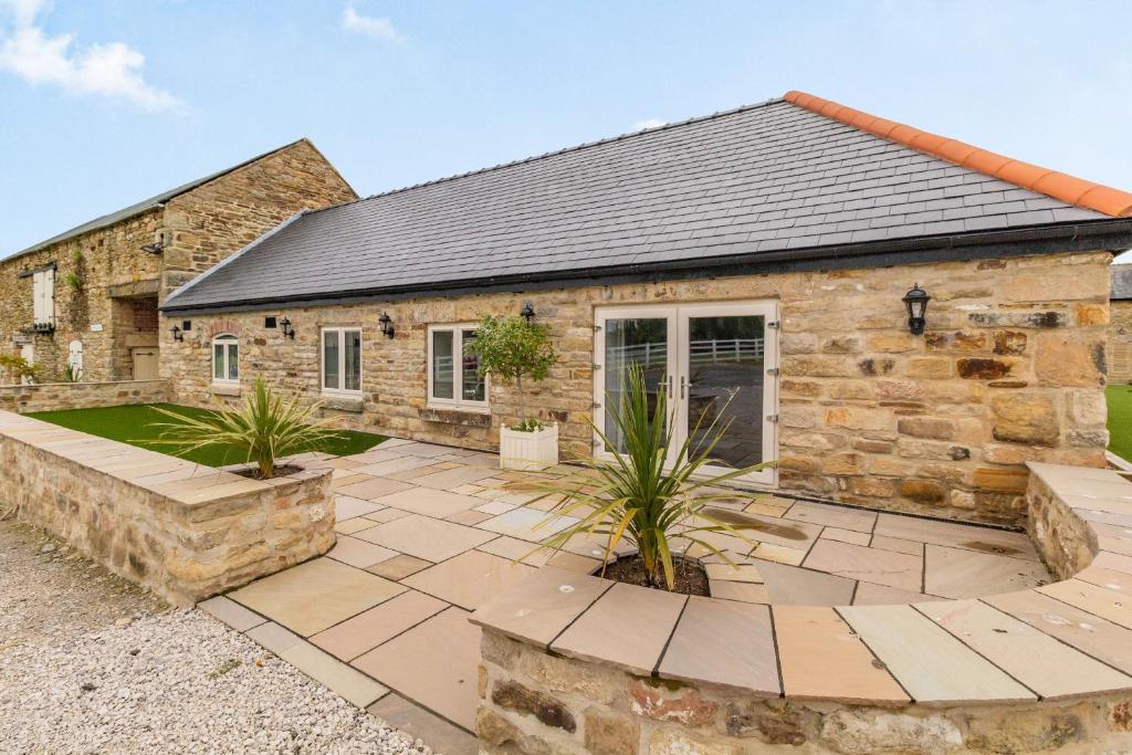 a stone house with a courtyard in front of it at The Dairy in Chesterfield