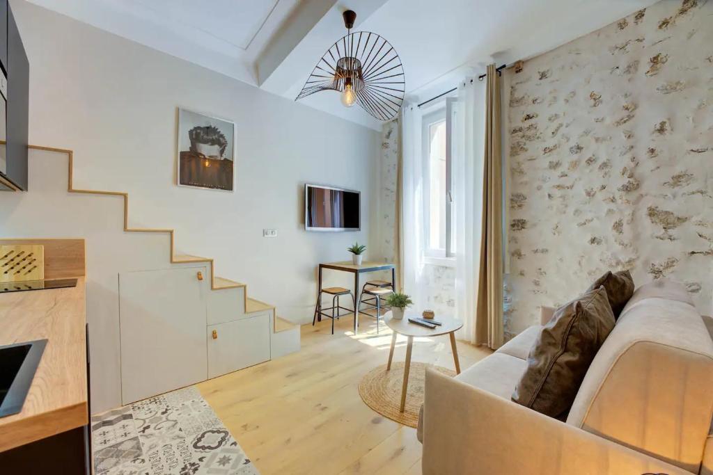 a living room with a couch and a staircase at Duplex Studio Apt Mezzanine near Shops & Cafes in Antibes