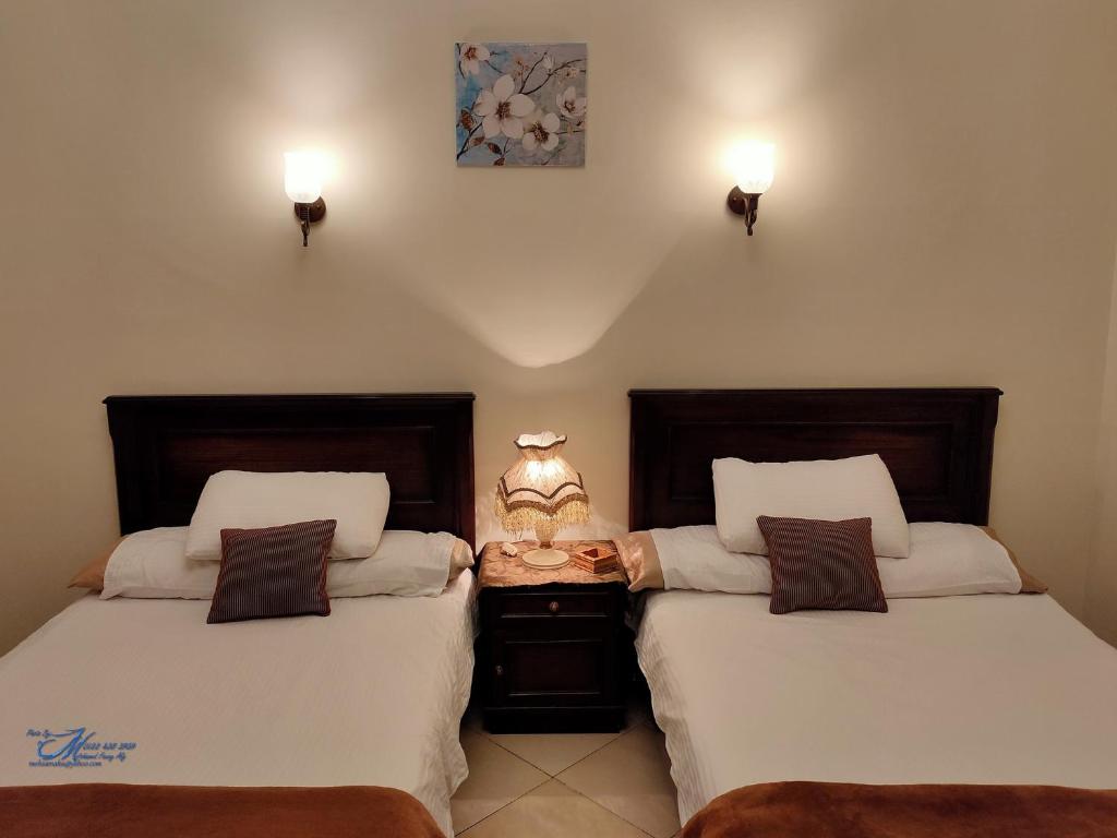 2 Betten nebeneinander in einem Zimmer in der Unterkunft Triomphe Hostel in Alexandria