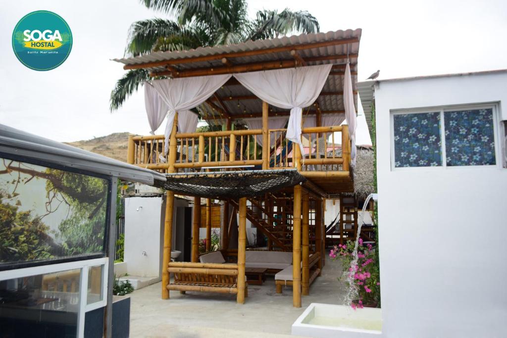 einen Pavillon mit einem Bett in der Mitte eines Hauses in der Unterkunft Soga Hostal in Santa Marianita