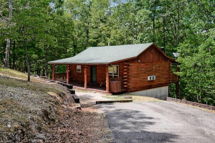 a log cabin with a garage in the woods at Cabin in the woods WIFI, 1 story in Eureka Springs