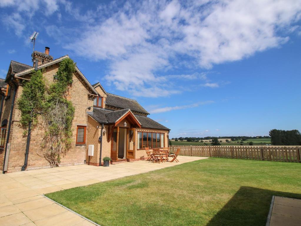 einem externen Blick auf ein Haus mit einer Terrasse in der Unterkunft Ellenhall Farm Cottage in Stafford