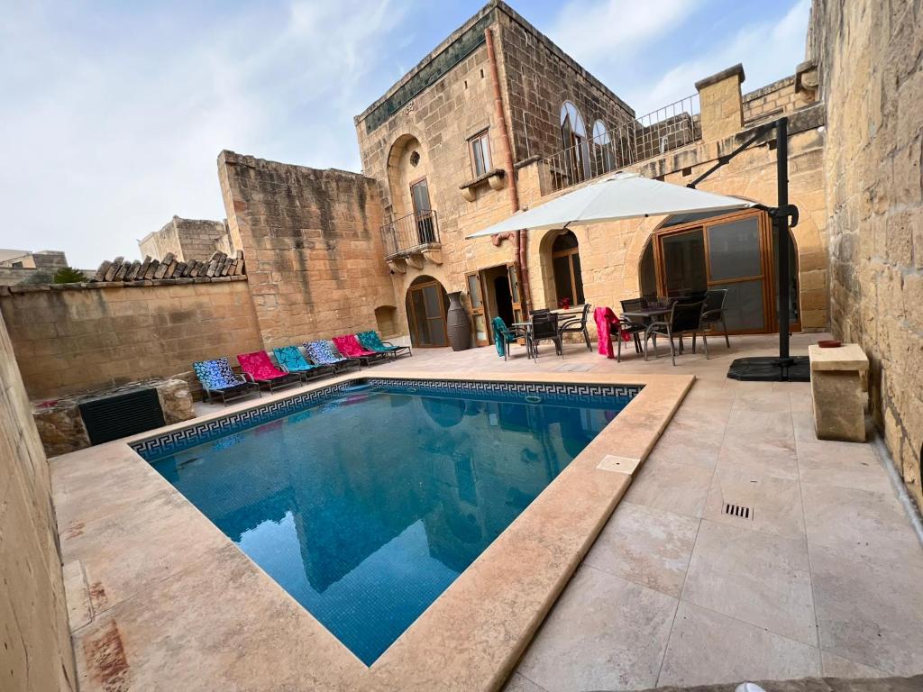 a swimming pool in the courtyard of a building at Birbuba House 2 in Għarb