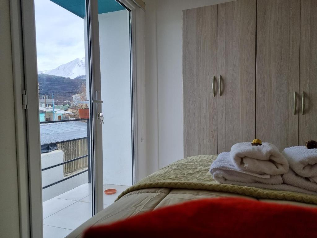 ein Schlafzimmer mit einem Bett mit Handtüchern und einem Fenster in der Unterkunft Yoppen: Duplex 2 dormitorios en Ushuaia in Ushuaia