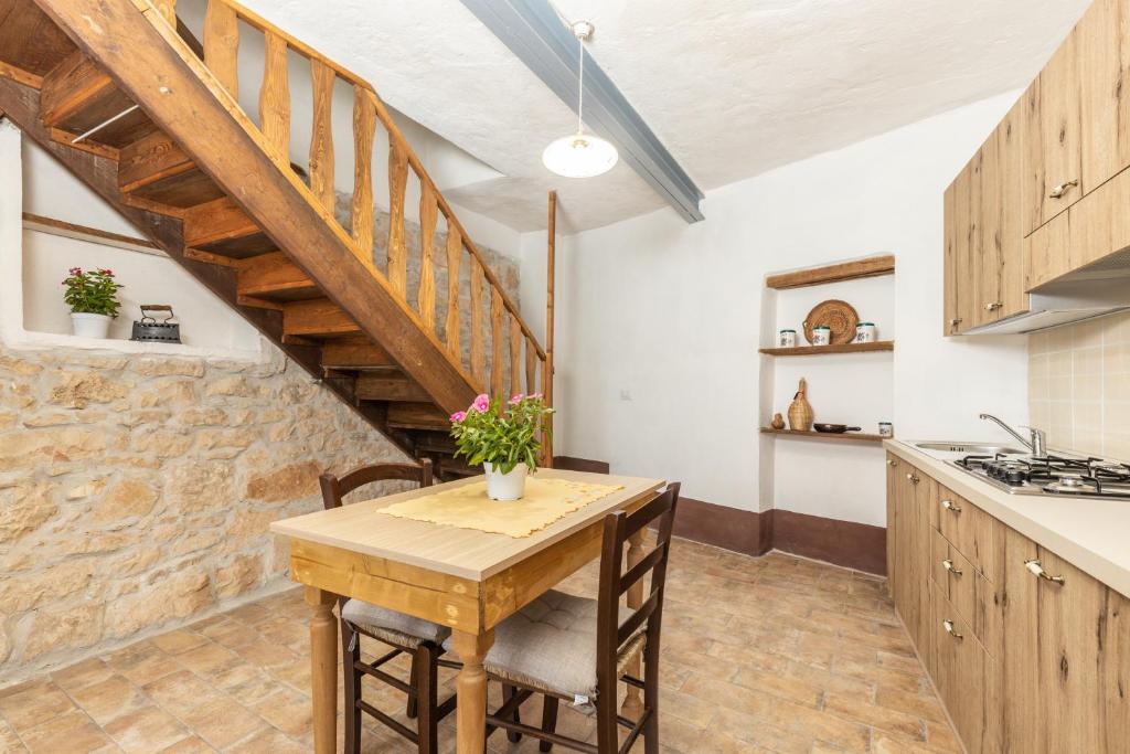 une cuisine avec une table en bois et un escalier dans l'établissement Antico Forno Baunei, à Baunei